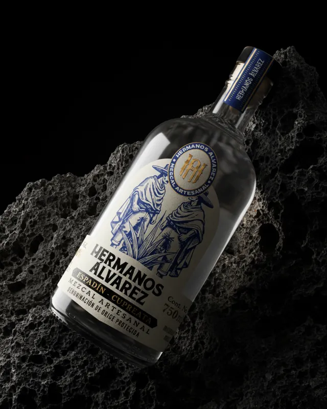 Botella de mezcal artesanal Hermanos Álvarez sobre roca volcánica, marca desarrollada por Dobalab